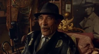 Movie still from “Black Cat, White Cat” (1998), directed by Emir Kusturica – An older man wearing a hat and a suit; Close Up shot, High angle