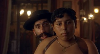 Movie still from “Black Cat, White Cat” (1998), directed by Emir Kusturica – A man and a boy are standing next to each other; Close Up shot, Over the shoulder angle