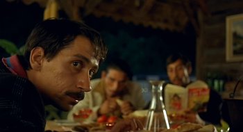 Movie still from “Black Cat, White Cat” (1998), directed by Emir Kusturica – A group of men sitting at a table eating food; Close Up shot, Over the shoulder angle