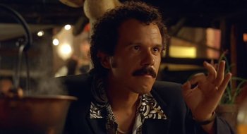 Movie still from “Black Cat, White Cat” (1998), directed by Emir Kusturica – A person wearing a suit and tie; Close Up shot, Low angle