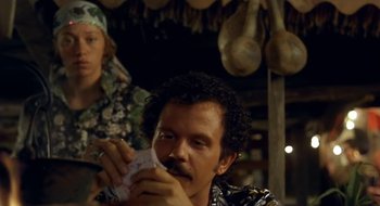 Movie still from “Black Cat, White Cat” (1998), directed by Emir Kusturica – A man holding a piece of paper in front of another man; Close Up shot, Over the shoulder angle