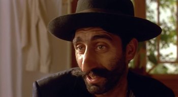 Movie still from “Black Cat, White Cat” (1998), directed by Emir Kusturica – A person wearing a hat; Close Up shot, Low angle