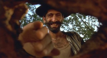 Movie still from “Black Cat, White Cat” (1998), directed by Emir Kusturica – A person with a beard and a hat; Close Up shot, Low angle