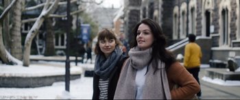 Movie still from “Black Christmas” (2019), directed by Sophia Takal – Two women walking down the street wearing scarves; Close Up shot, Low angle