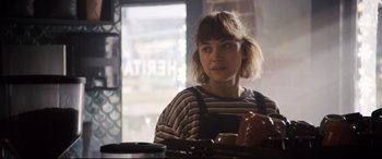 Movie still from “Black Christmas” (2019), directed by Sophia Takal – A woman sitting at a table in front of an apple; Close Up shot, Over the shoulder angle