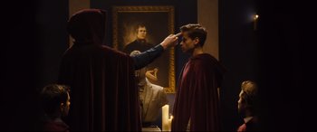 Movie still from “Black Christmas” (2019), directed by Sophia Takal – A man in a red robe is getting ready for a ceremony; Medium shot, Over the shoulder angle