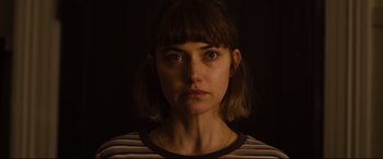 Movie still from “Black Christmas” (2019), directed by Sophia Takal – A person wearing a striped t - shirt; Close Up shot, High angle