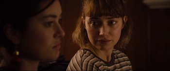 Movie still from “Black Christmas” (2019), directed by Sophia Takal – A woman sitting next to another woman in front of a wall; Close Up shot, Over the shoulder angle