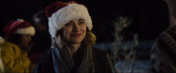 Movie still from “Black Christmas” (2019), directed by Sophia Takal – A woman wearing a santa hat and a scarf; Close Up shot, Over the shoulder angle