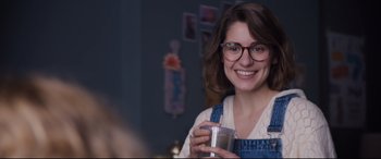 Movie still from “Black Christmas” (2019), directed by Sophia Takal – A woman wearing glasses and holding a cup; Close Up shot, Over the shoulder angle