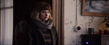 Movie still from “Black Christmas” (2019), directed by Sophia Takal – A young woman wearing a sweater and a scarf; Close Up shot, Over the shoulder angle