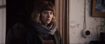 Movie still from “Black Christmas” (2019), directed by Sophia Takal – A woman wearing a scarf standing in front of a window; Close Up shot, Over the shoulder angle