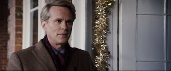 Movie still from “Black Christmas” (2019), directed by Sophia Takal – A person wearing a suit and tie; Close Up shot, Over the shoulder angle