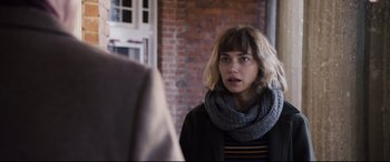 Movie still from “Black Christmas” (2019), directed by Sophia Takal – A woman wearing a gray scarf looking into a mirror; Close Up shot, Over the shoulder angle