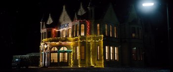 Movie still from “Black Christmas” (2019), directed by Sophia Takal – A building that is lit up at night time; Extreme Wide shot, Low angle