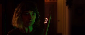 Movie still from “Black Christmas” (2019), directed by Sophia Takal – A woman is holding a stick in a dark room; Close Up shot, Over the shoulder angle
