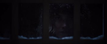 Movie still from “Black Christmas” (2019), directed by Sophia Takal – A woman looking out of a window at night; Extreme Close Up shot, Over the shoulder angle