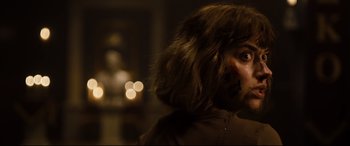 Movie still from “Black Christmas” (2019), directed by Sophia Takal – A person's face with lights in the background; Close Up shot, Over the shoulder angle