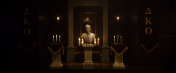 Movie still from “Black Christmas” (2019), directed by Sophia Takal – A bust of abraham lincoln in front of candles in a room; Extreme Wide shot, Low angle