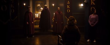 Movie still from “Black Christmas” (2019), directed by Sophia Takal – A group of people dressed up in robes and hoods; Wide shot, Over the shoulder angle