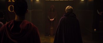 Movie still from “Black Christmas” (2019), directed by Sophia Takal – A woman in a red robe stands in front of another woman in a red robe; Wide shot, Over the shoulder angle