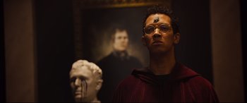 Movie still from “Black Christmas” (2019), directed by Sophia Takal – A man standing in front of a bust of a person; Close Up shot, Low angle