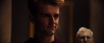 Movie still from “Black Christmas” (2019), directed by Sophia Takal – A young man with blonde hair looking into the distance; Close Up shot, Over the shoulder angle