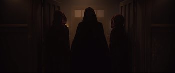 Movie still from “Black Christmas” (2019), directed by Sophia Takal – A group of people standing in the dark; Wide shot, Low angle