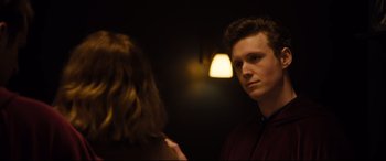Movie still from “Black Christmas” (2019), directed by Sophia Takal – A man and a woman standing next to each other in a room; Close Up shot, Over the shoulder angle