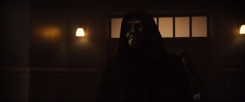 Movie still from “Black Christmas” (2019), directed by Sophia Takal – A man in a black mask and a black robe; Close Up shot, Low angle