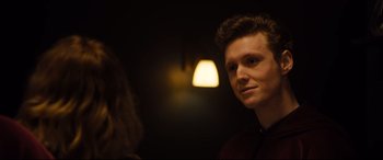 Movie still from “Black Christmas” (2019), directed by Sophia Takal – A man standing next to a woman in front of a light fixture; Close Up shot, Over the shoulder angle
