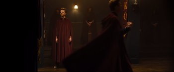 Movie still from “Black Christmas” (2019), directed by Sophia Takal – A man wearing a red robe and a black cape; Wide shot, Low angle