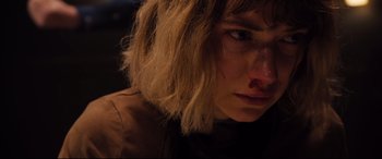 Movie still from “Black Christmas” (2019), directed by Sophia Takal – A woman's face in a dark room; Close Up shot, High angle