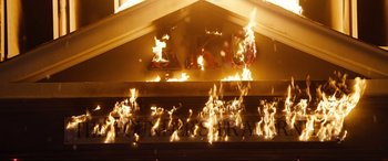 Movie still from “Black Christmas” (2019), directed by Sophia Takal – A fire is burning on the outside of a building; Extreme Wide shot, Low angle