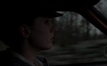 Movie still from “Black Moon” (1975), directed by Louis Malle – A woman in a hat looking out of a car window; Close Up shot, Low angle