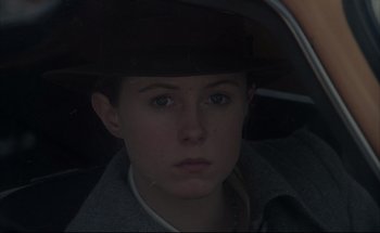 Movie still from “Black Moon” (1975), directed by Louis Malle – A person with a hat in a car looking at the camera; Close Up shot, Over the shoulder angle