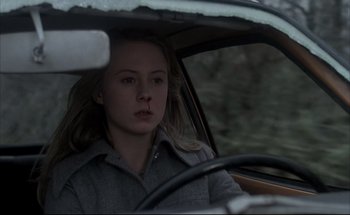 Movie still from “Black Moon” (1975), directed by Louis Malle – A woman sitting in the driver's seat of a car; Close Up shot, Low angle