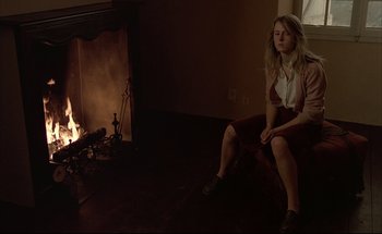 Movie still from “Black Moon” (1975), directed by Louis Malle – A woman sitting in front of a fire place; Medium shot, High angle