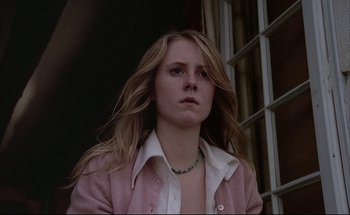 Movie still from “Black Moon” (1975), directed by Louis Malle – A woman with long blonde hair wearing a pink jacket; Close Up shot, Low angle