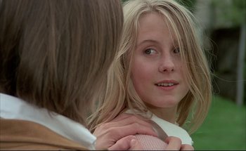 Movie still from “Black Moon” (1975), directed by Louis Malle – A young girl looking into a mirror while holding her hand on her shoulder; Close Up shot, Over the shoulder angle