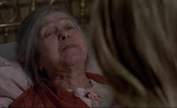 Movie still from “Black Moon” (1975), directed by Louis Malle – An older woman sitting in front of a mirror; Close Up shot, Over the shoulder angle