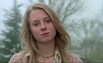 Movie still from “Black Moon” (1975), directed by Louis Malle – A woman with long blonde hair wearing a necklace; Close Up shot, Low angle