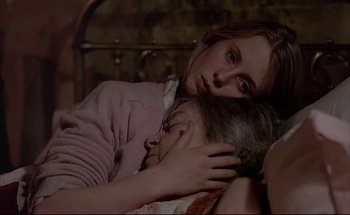 Movie still from “Black Moon” (1975), directed by Louis Malle – Two young girls laying in a bed holding each other's head; Close Up shot, High angle
