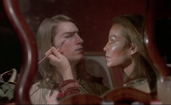 Movie still from “Black Moon” (1975), directed by Louis Malle – A man and a woman looking at each other in a mirror; Close Up shot, Over the shoulder angle