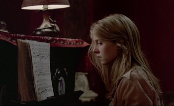 Movie still from “Black Moon” (1975), directed by Louis Malle – A young girl is looking at a sheet of music; Close Up shot, Over the shoulder angle