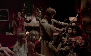 Movie still from “Black Moon” (1975), directed by Louis Malle – A group of people sitting in a living room; Wide shot, High angle