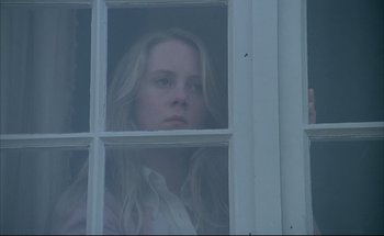 Movie still from “Black Moon” (1975), directed by Louis Malle – A woman looking out of a window at the outside; Close Up shot, Low angle