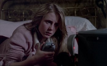 Movie still from “Black Moon” (1975), directed by Louis Malle – A woman holding a remote control in her hand; Close Up shot, High angle