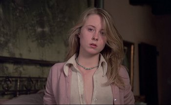 Movie still from “Black Moon” (1975), directed by Louis Malle – A young woman with long blonde hair wearing a white shirt and a pink jacket; Close Up shot, Low angle
