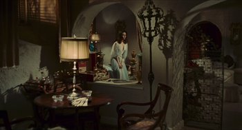 Movie still from “Black Sabbath” (1963), directed by Mario Bava – A woman sitting on a window sill in a room; Wide shot, High angle